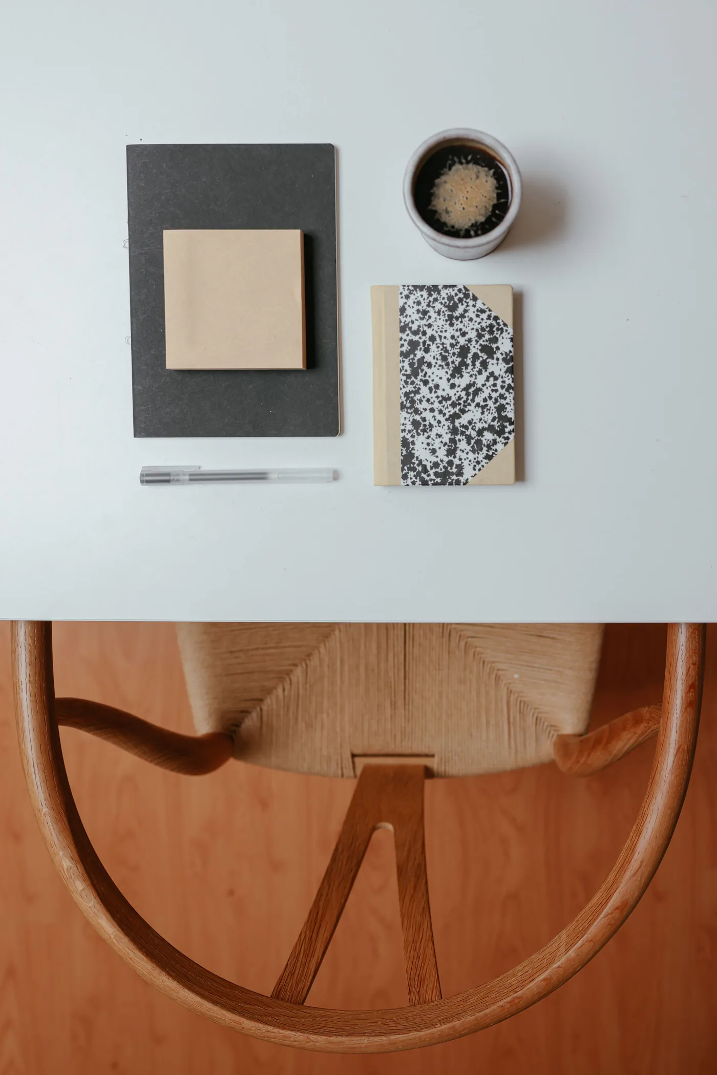 Notebooks, pen and coffee arranged on a modern workspace