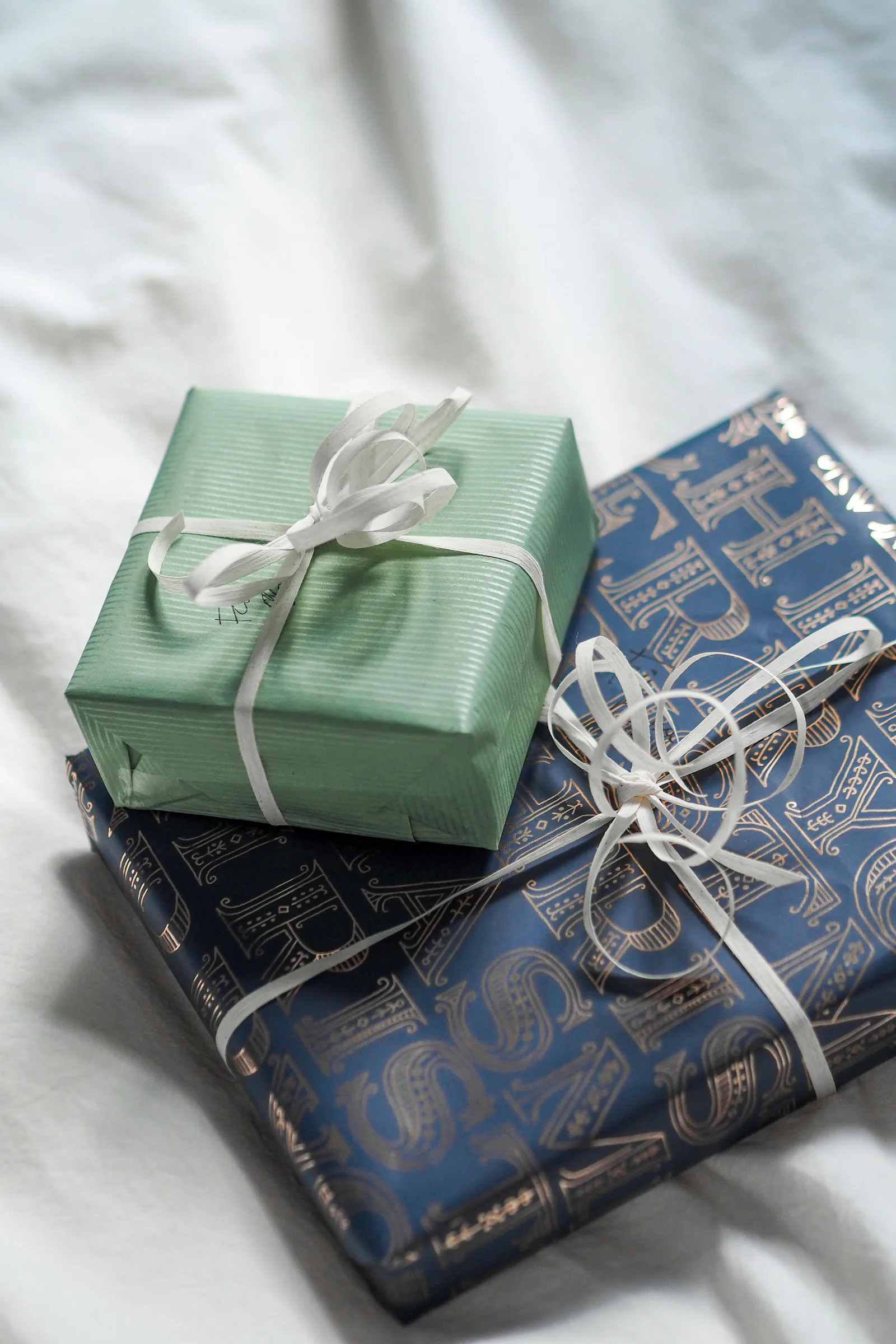 Blue and sage gift boxes wrapped with white ribbon